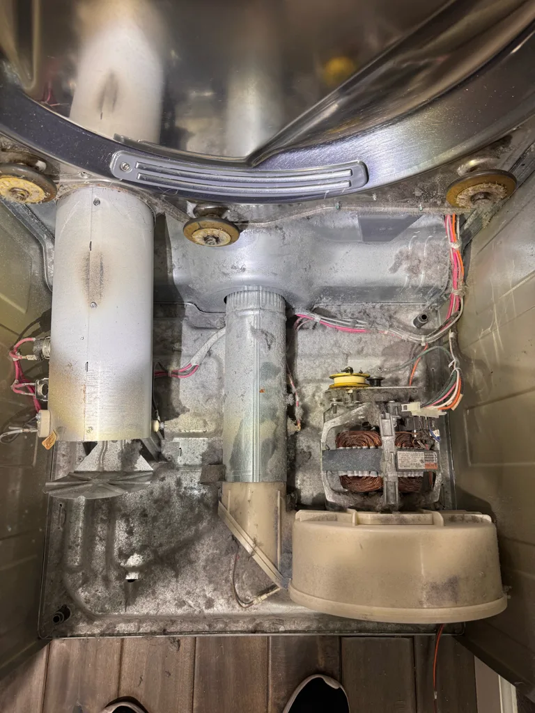 Inside an Electrolux dryer with the drum out, showing the blower, motor and rollers