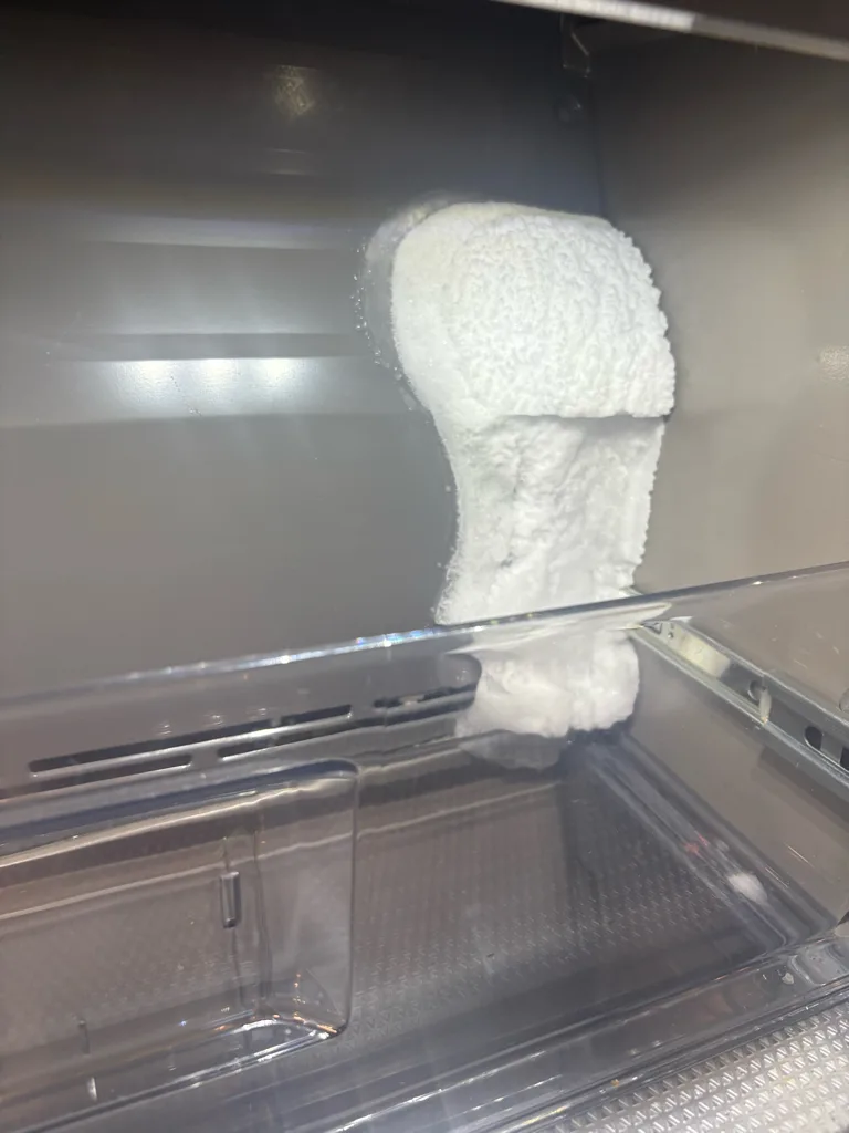 Clump of ice inside an Electrolux refrigerator that was leaking