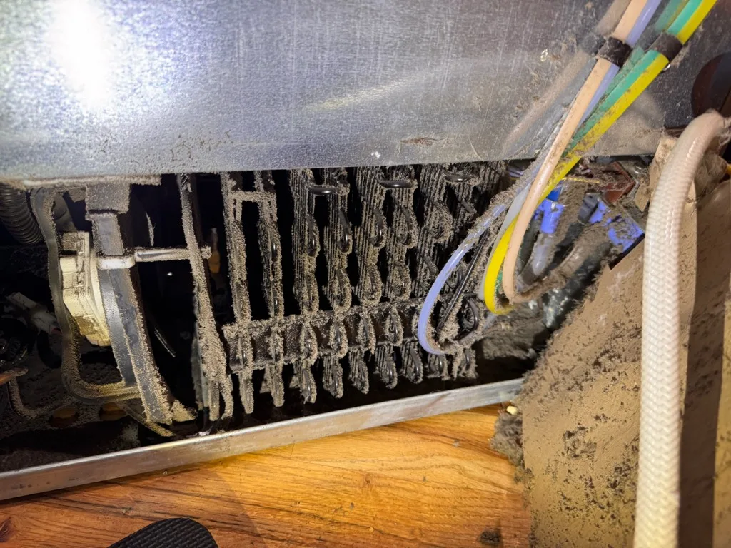 Machine compartment and wiring at the base of an Electrolux refrigerator