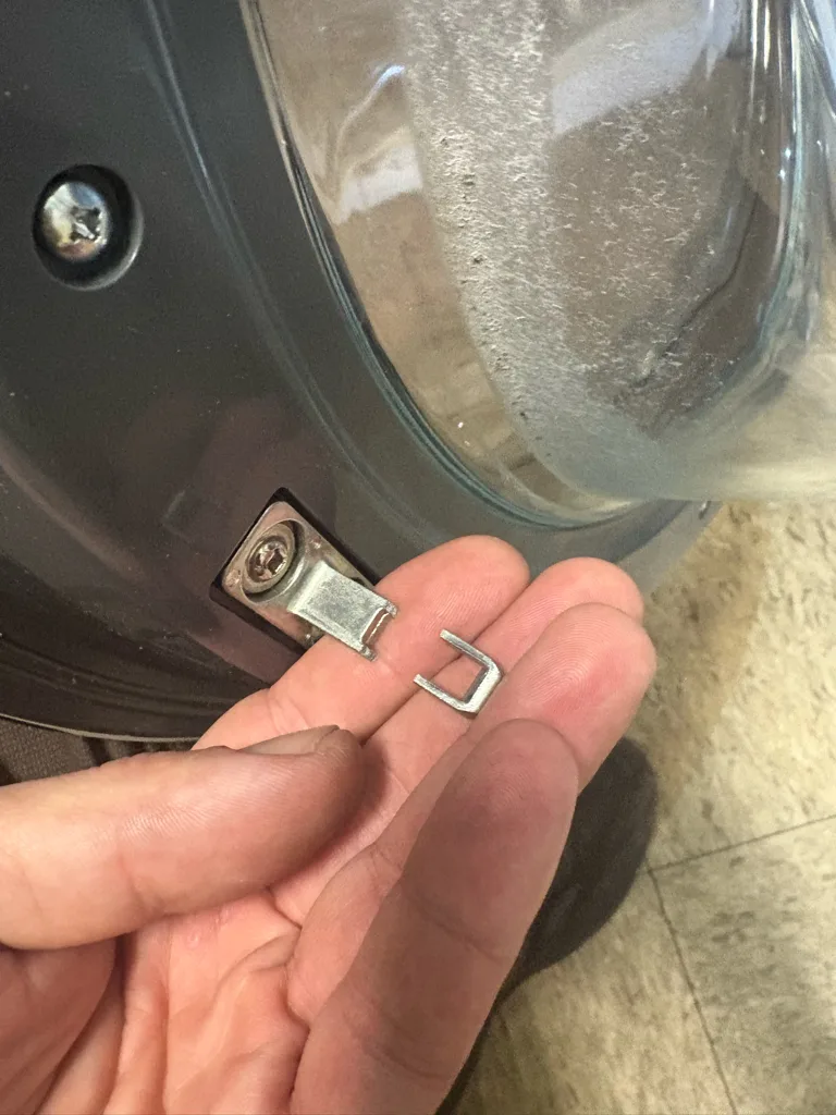 Broken metal door strike from an Electrolux washer