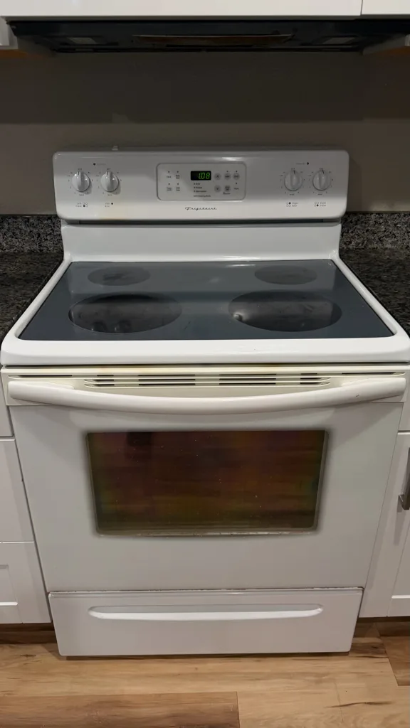 White Frigidaire electric range with a new glass cooktop