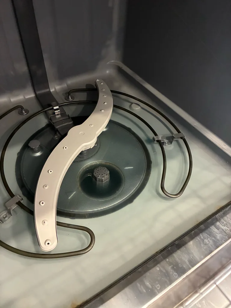 Lower spray arm and heating element inside a GE dishwasher