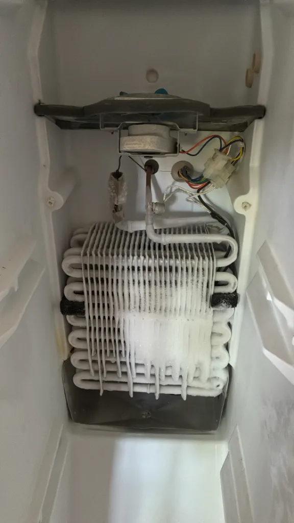 Evaporator coil exposed inside a JennAir refrigerator freezer