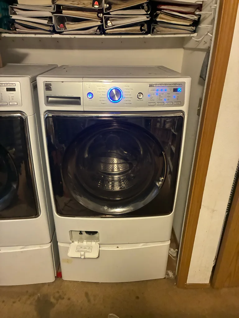 Kenmore Elite front-load washer on a pedestal in a Denver-area laundry