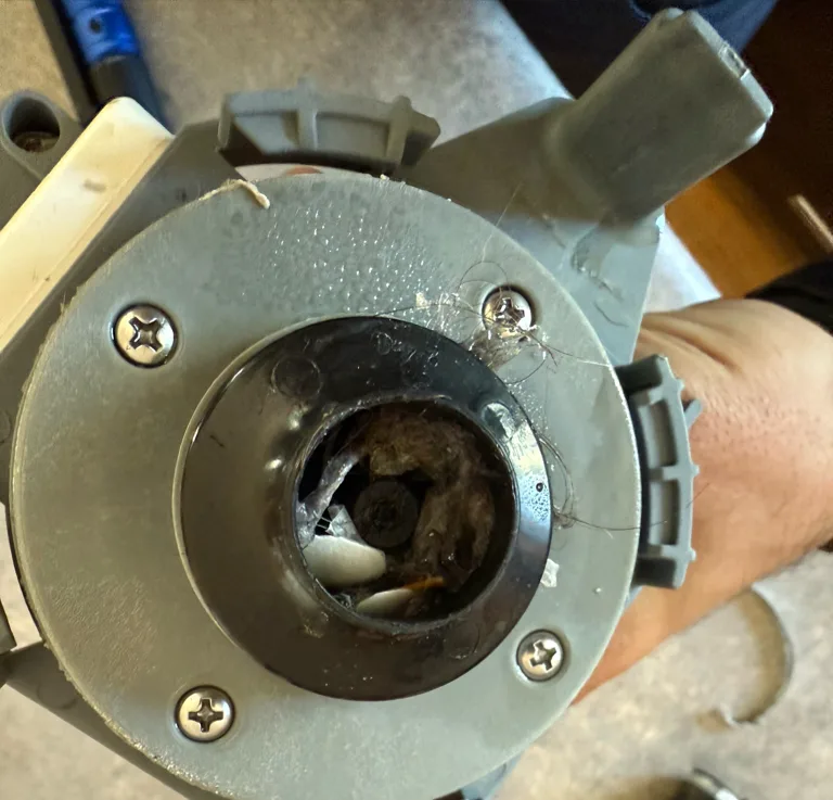 Failed pump with debris inside, removed from a KitchenAid dishwasher