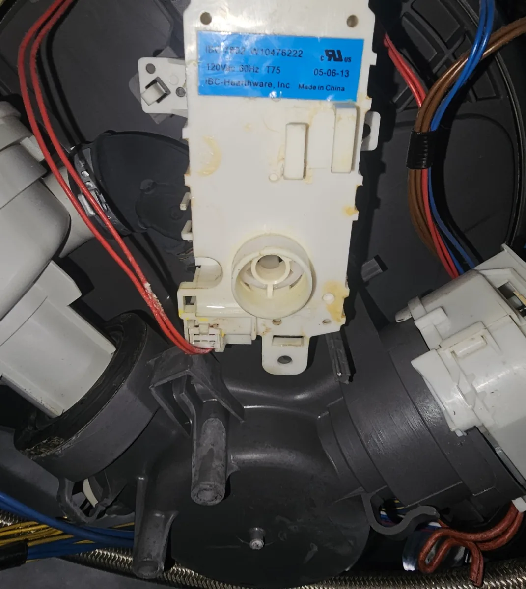 Pump and motor assembly underneath a KitchenAid dishwasher