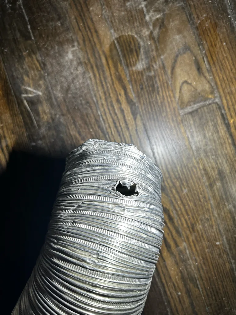 Damaged foil dryer vent hose with a hole