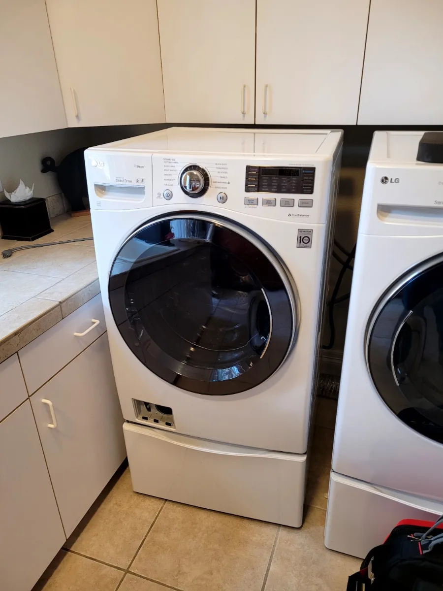 White LG front-load washer on a pedestal in a Denver-area laundry room