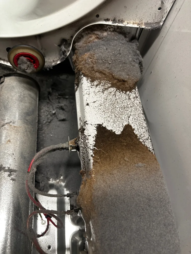 Thick lint buildup in the blower duct of a Maytag dryer