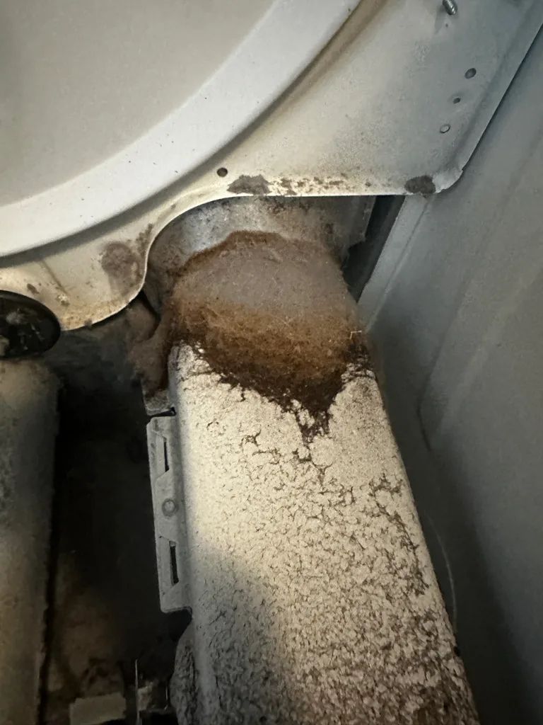 Lint packed into the exhaust duct inside a Maytag dryer
