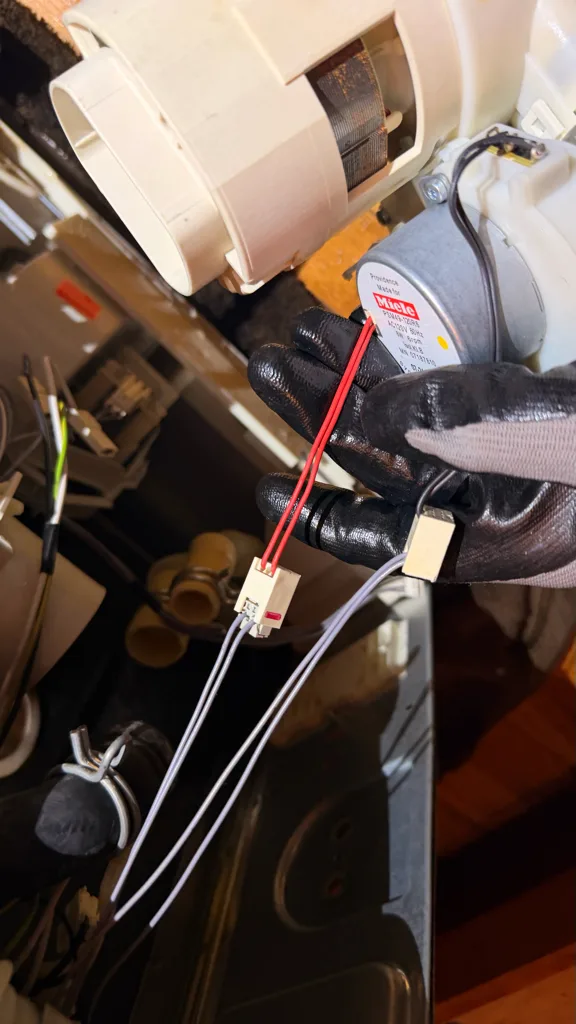 Circulation pump and wiring under a Miele dishwasher