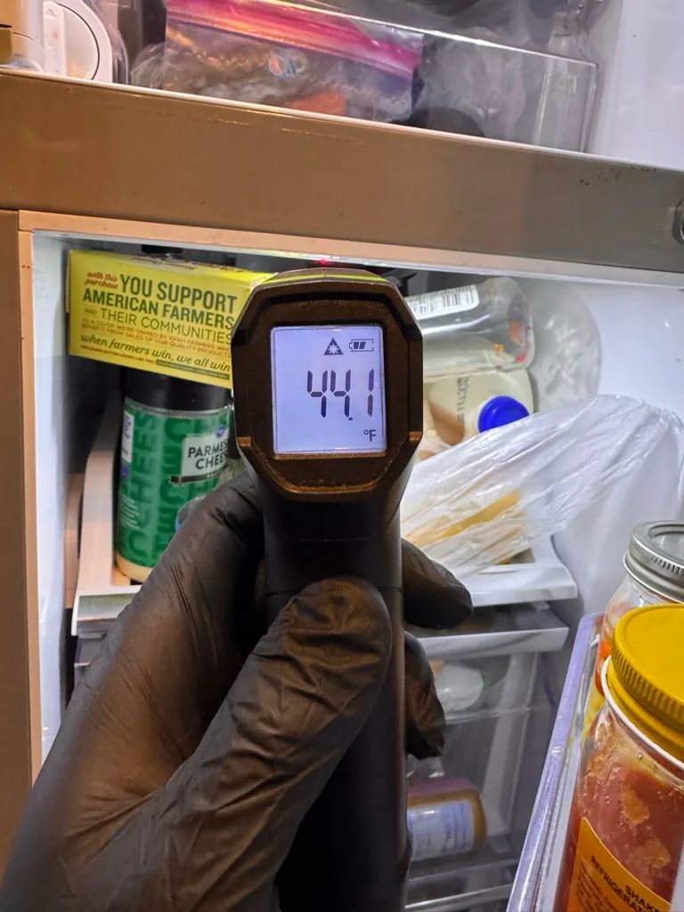 Technician measuring fresh-food temperature in a Samsung refrigerator