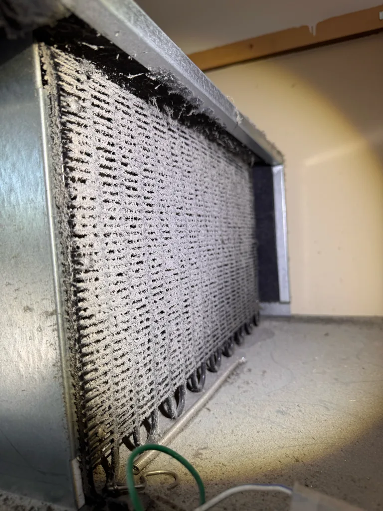 Heavily clogged condenser on a Sub-Zero built-in refrigerator