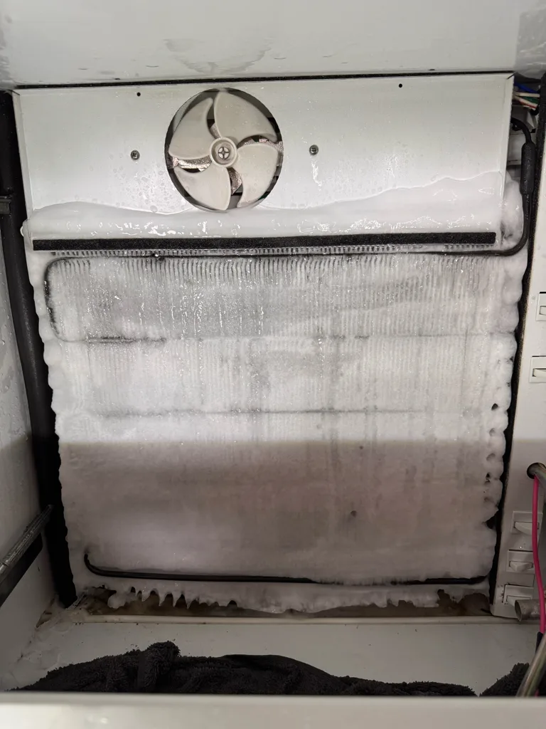 Evaporator coil covered in ice in a Sub-Zero freezer with a defrost failure