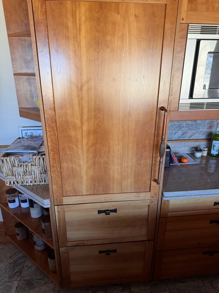 Sub-Zero refrigerator column and drawers hidden behind cherry wood panels