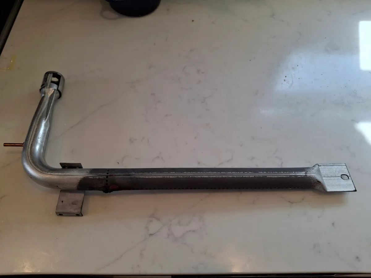 Burner tube removed from a Viking range cooktop