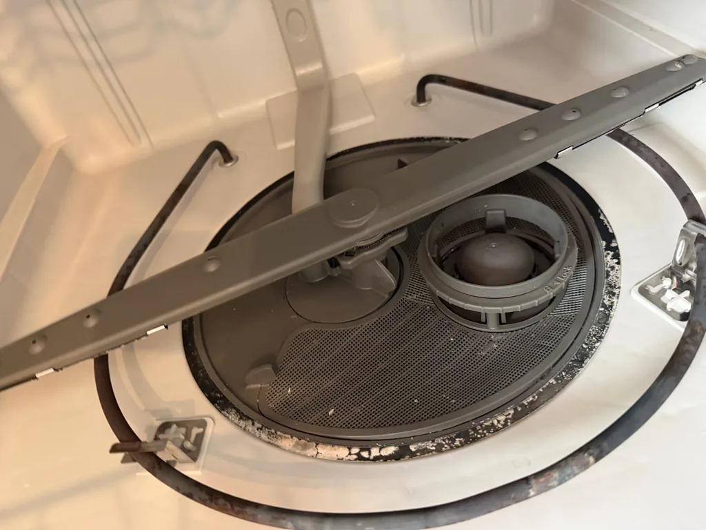 Filter and lower spray arm in the bottom of a Whirlpool dishwasher
