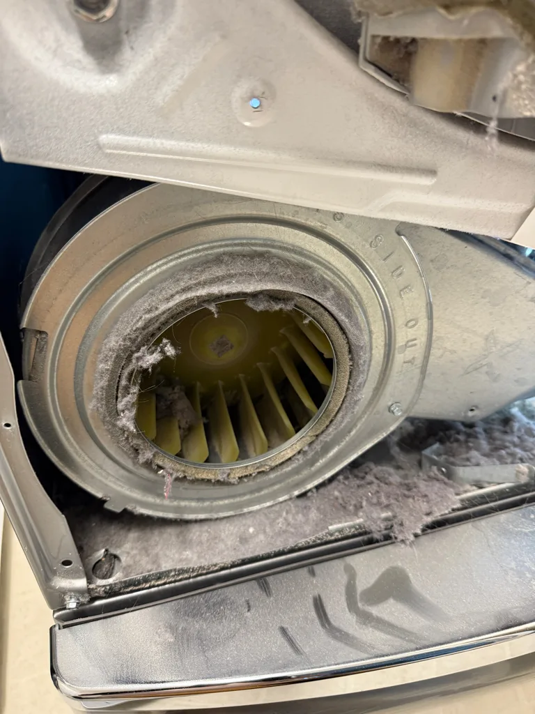 Lint built up around the blower wheel of a Whirlpool dryer