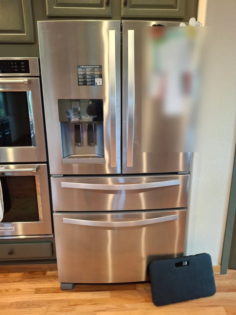 Stainless Whirlpool four-door French-door refrigerator in a Denver-area kitchen