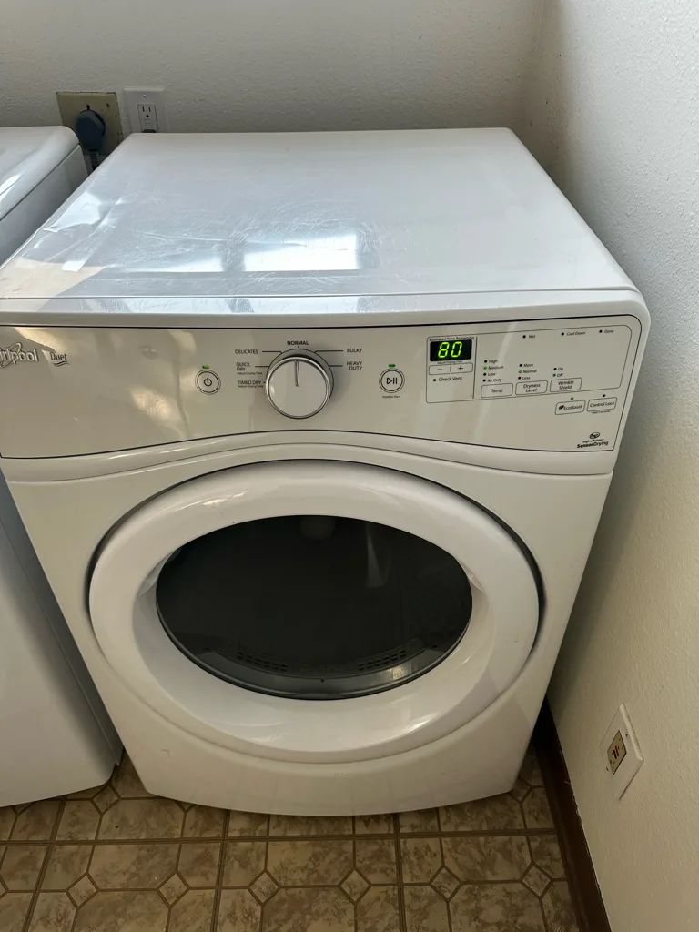 White Whirlpool front-load dryer in a Denver-area laundry room