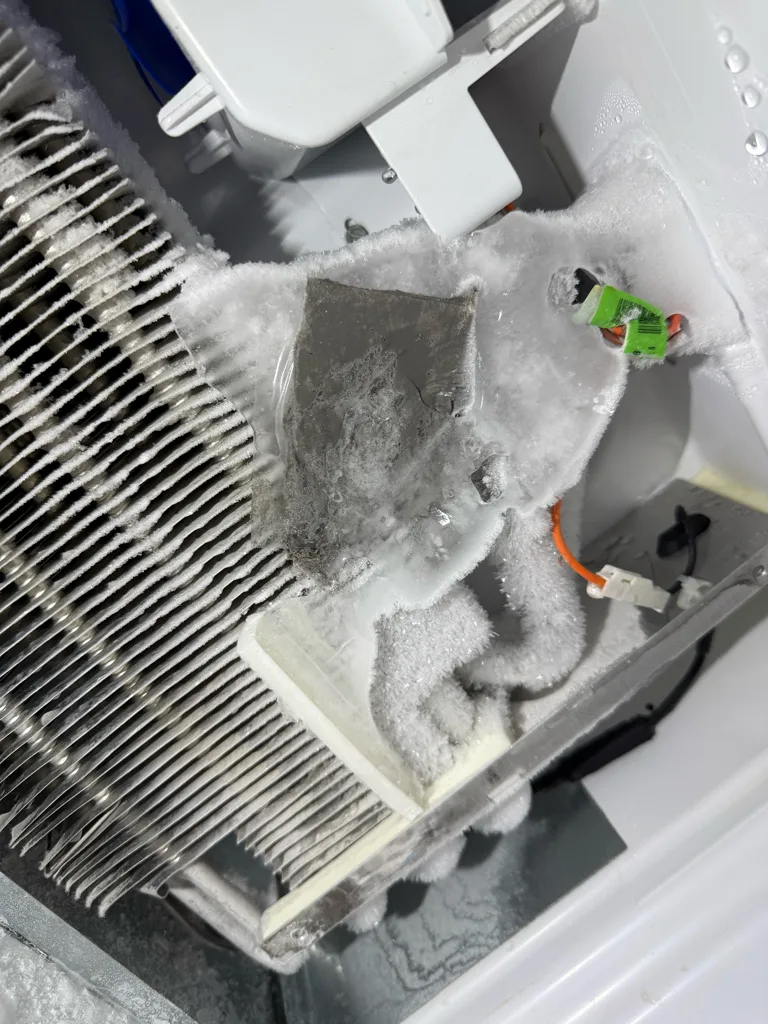 Evaporator area of a Whirlpool garage refrigerator during an evaporator fan replacement
